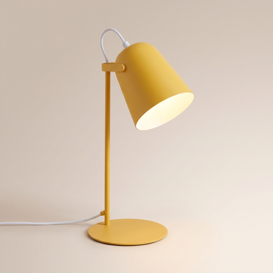 Yellow macaron iron bucket table lamp, lit, on a warm neutral background
