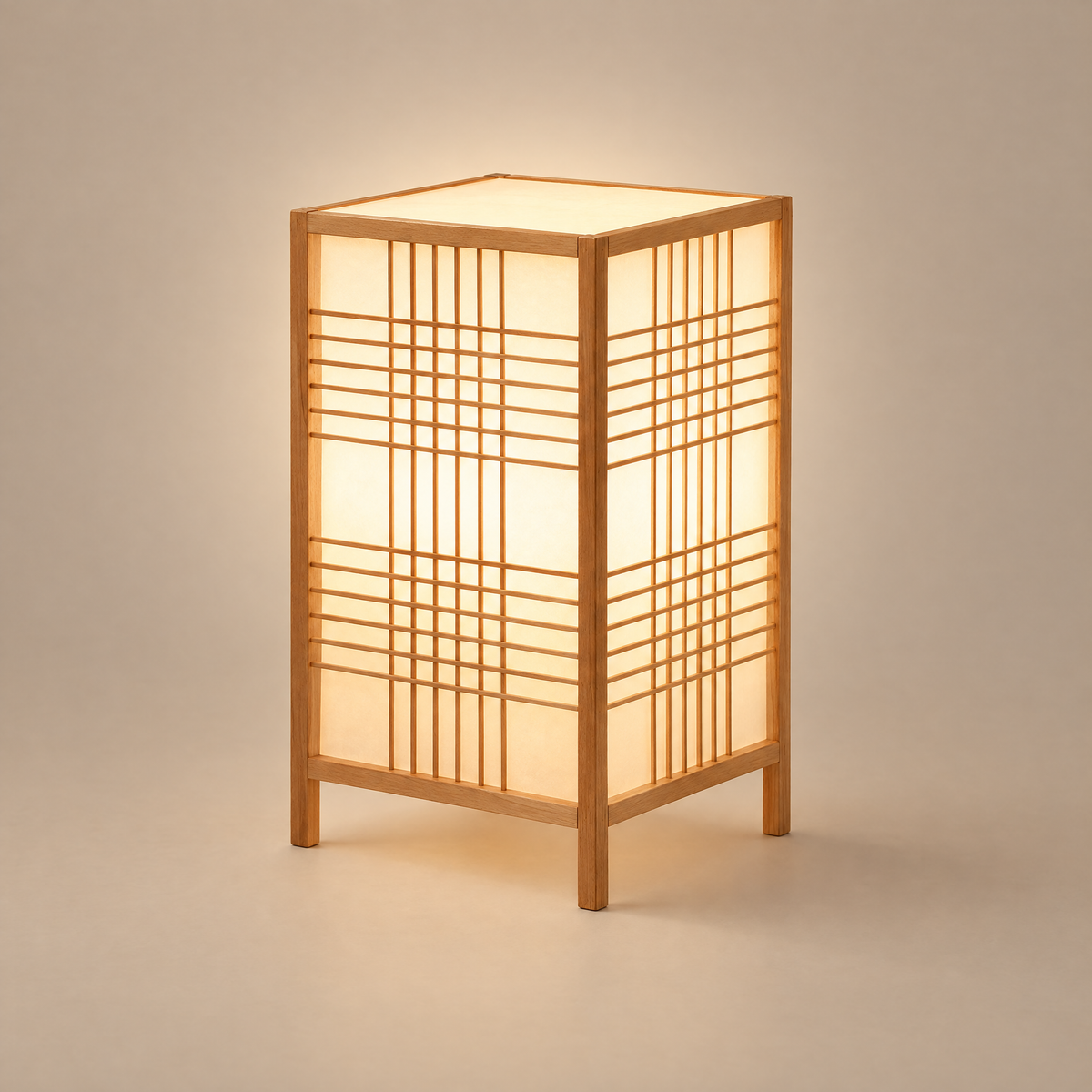 Shoji table lantern lamp with light wood frame and white lattice panels, lit, on a warm neutral background